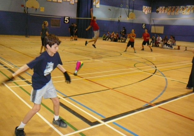 Jeune enfant s'apprêtant à servir un volant de Peteca
