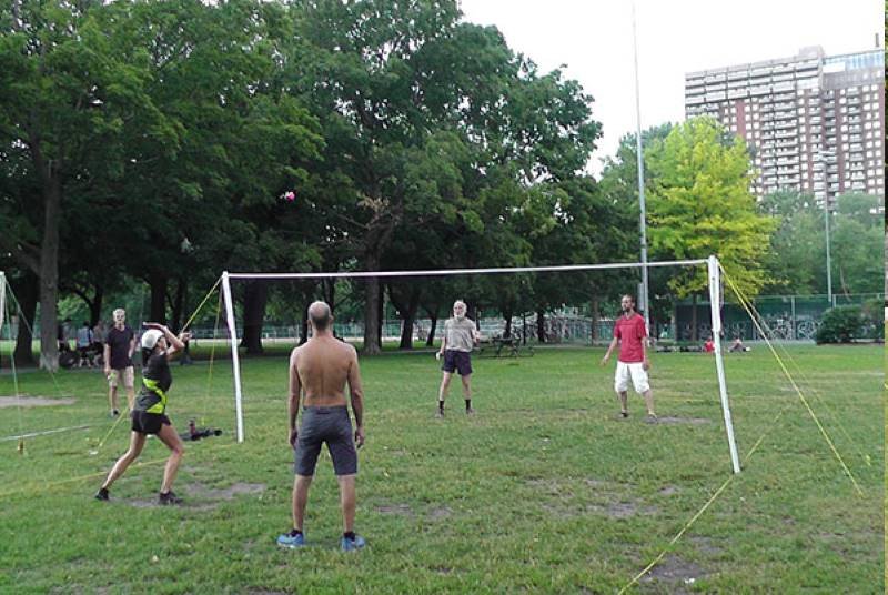 Joueuse de Peteca s'apprêtant à frapper le volant sur le terrain avec 3 autres personnes