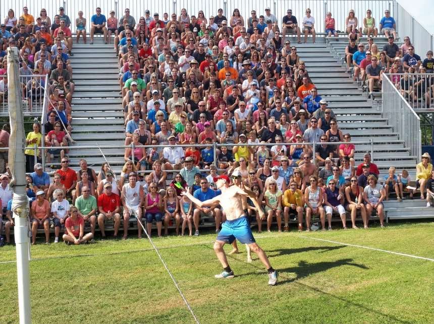 Joueur exécutant une touche de Peteca devant un public ajouté par l'IA