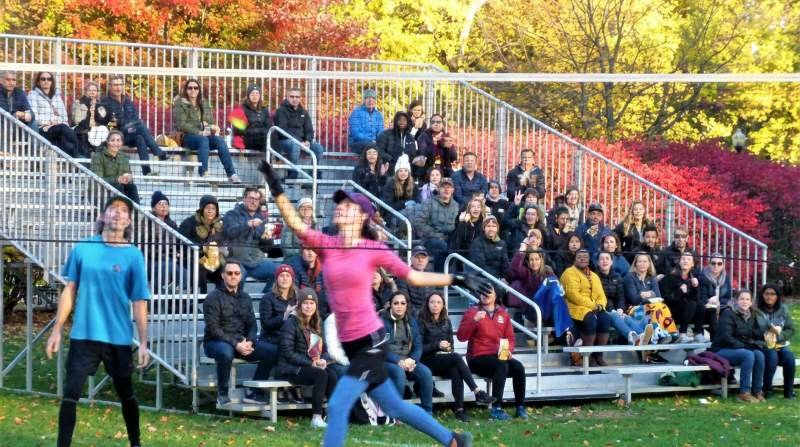Un joueur et une joueuse de Peteca au filet s'exécutent devant une foule qui occupe des estrades